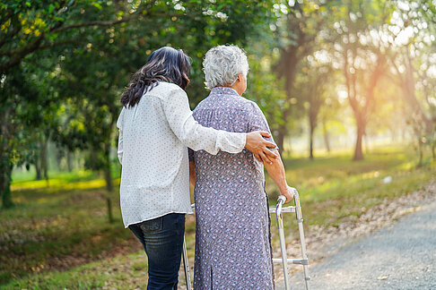 Help and care Asian senior or elderly old lady woman use walker with strong health while walking at park in happy fresh holiday.